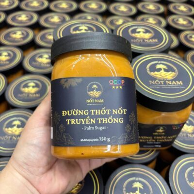 Hũ đường thốt nốt Nốt Nam 750g cầm trên tay, phía sau là nhiều hũ đường xếp chồng